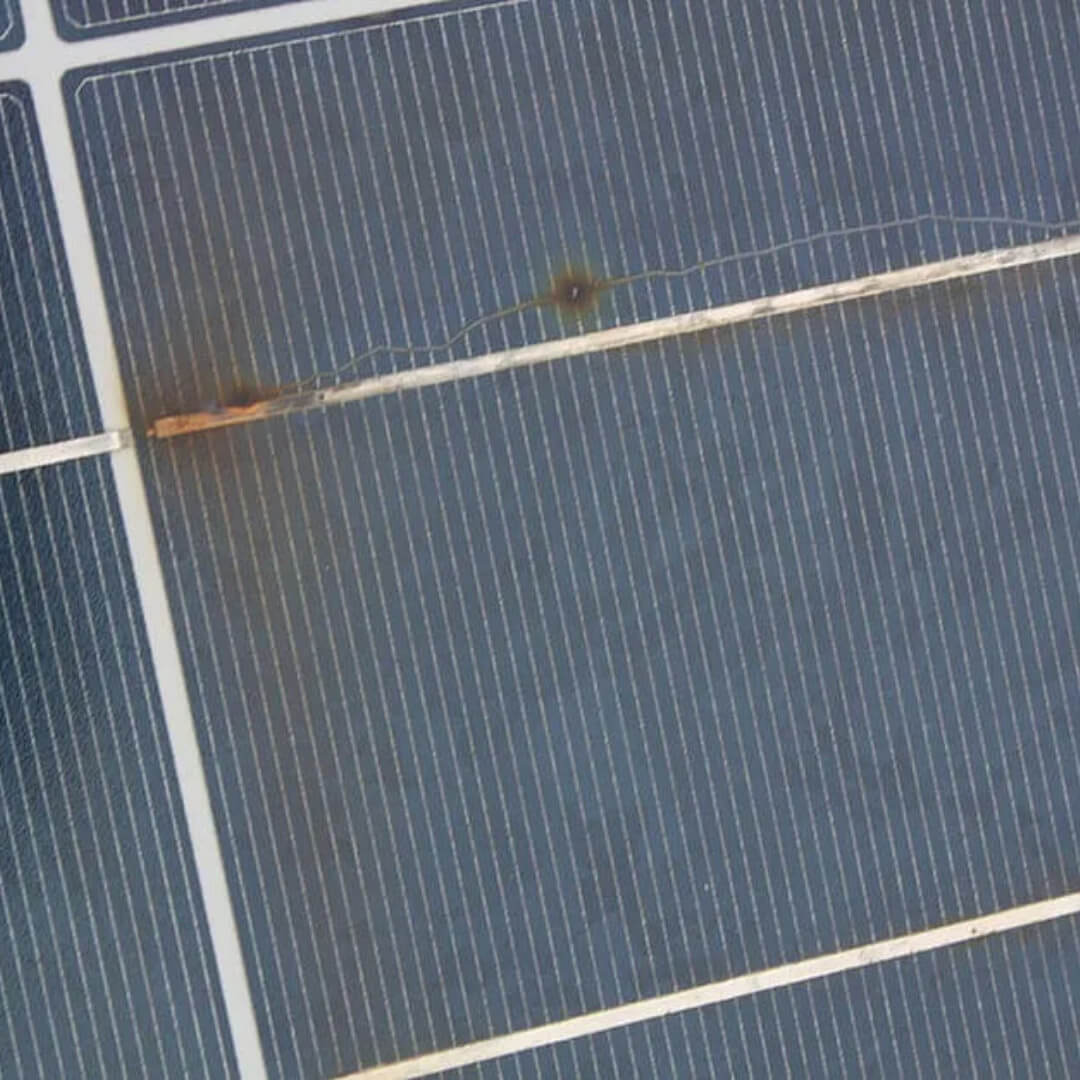 A solar panel with a rusty nail protruding from it, posing a potential hazard to the panel's functionality.