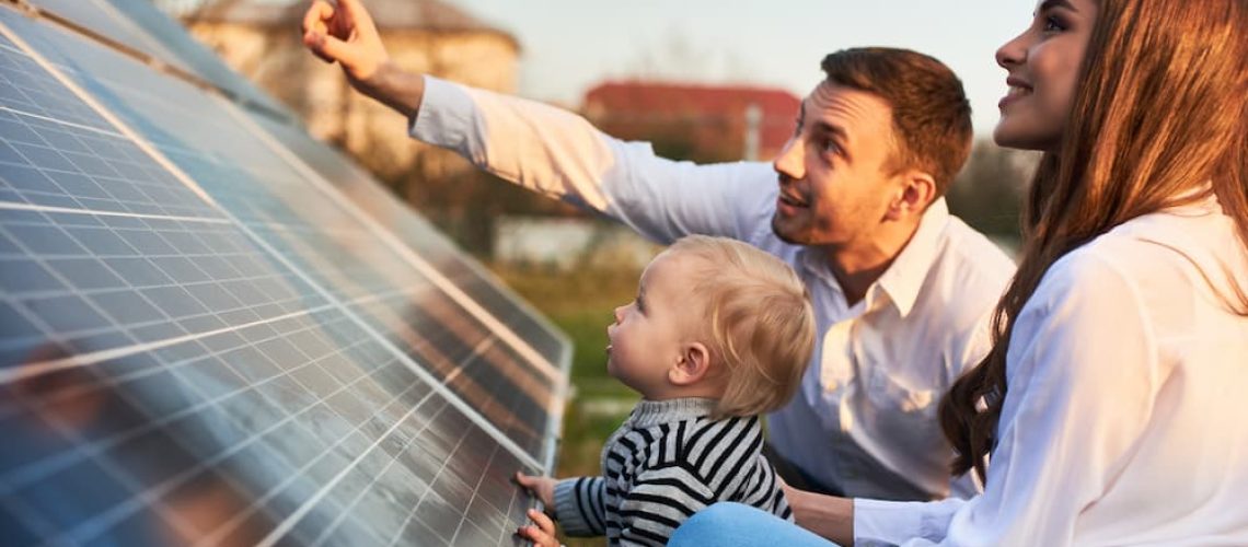 A mother and father show their toddler the new solar panels on their home installed by PepSolar